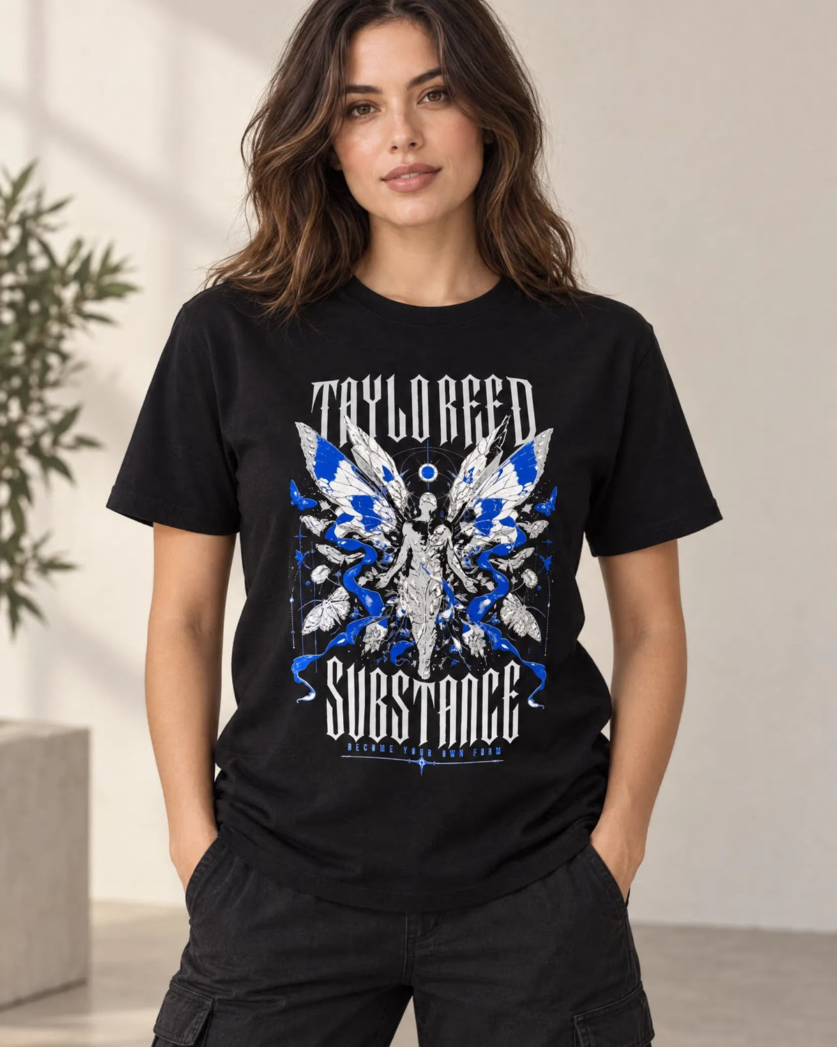 Model wearing the black Become Your Own Form graphic T-shirt, shown from the front with blue-and-white artwork.