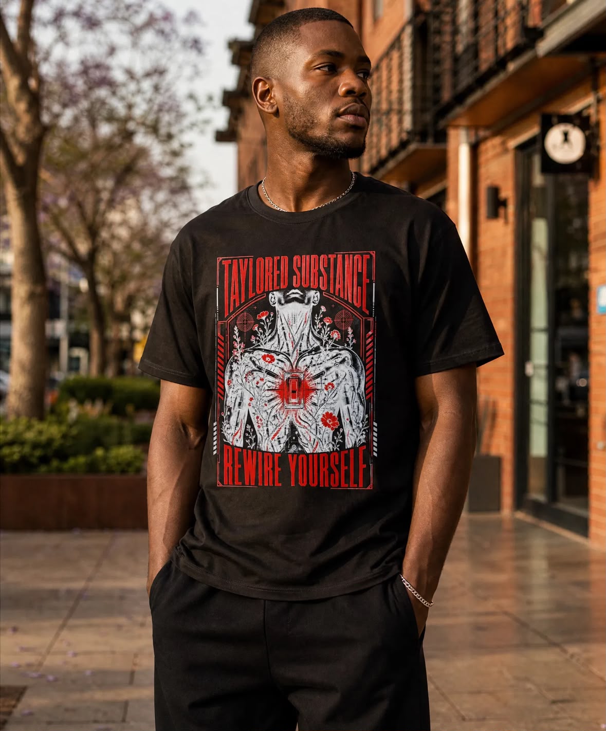 Model wearing the Rewire Yourself graphic T-shirt in an outdoor street setting.